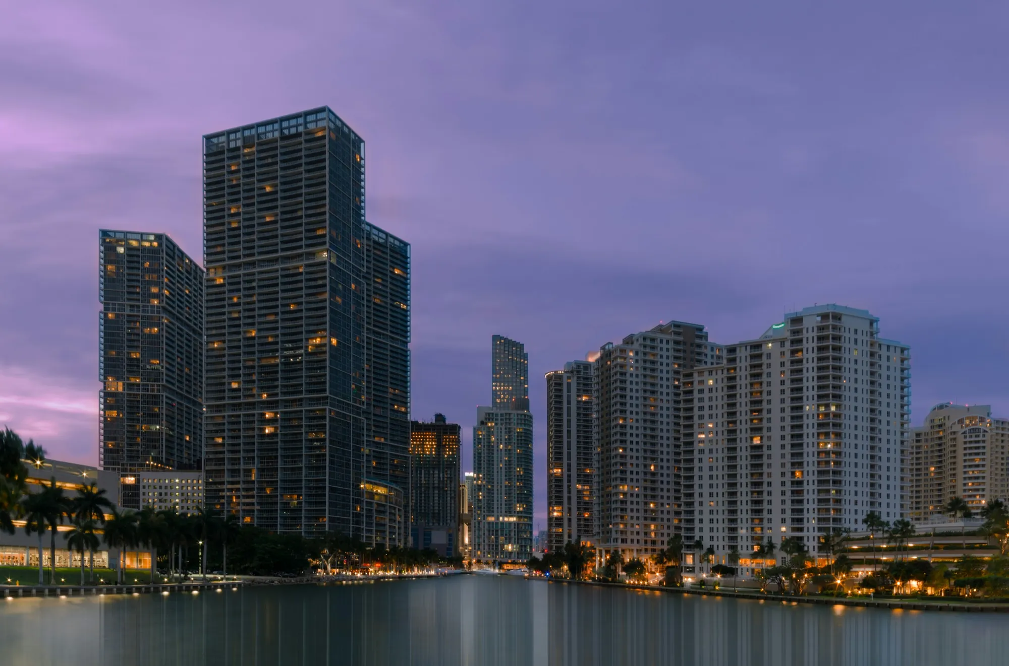 Brickell towers lit up over the water at twilight