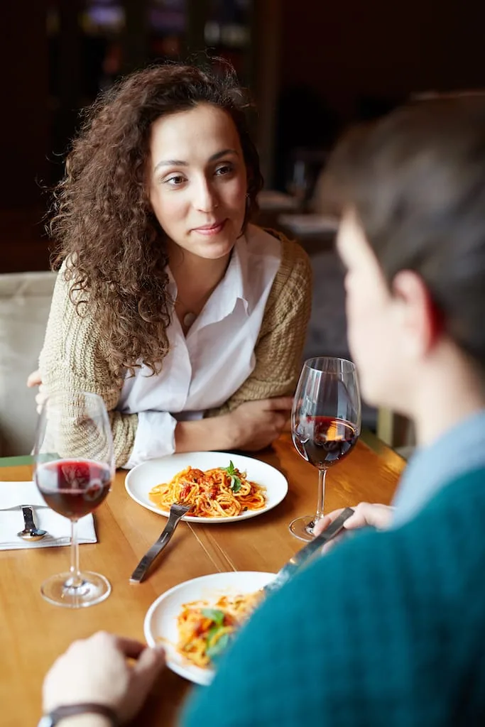 Two friends talking over dinner and wine