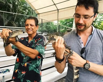 Two guests on a day out, one holding a small alligator