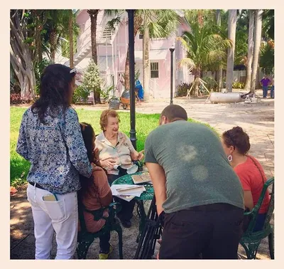 Guests gathered around a table under the trees